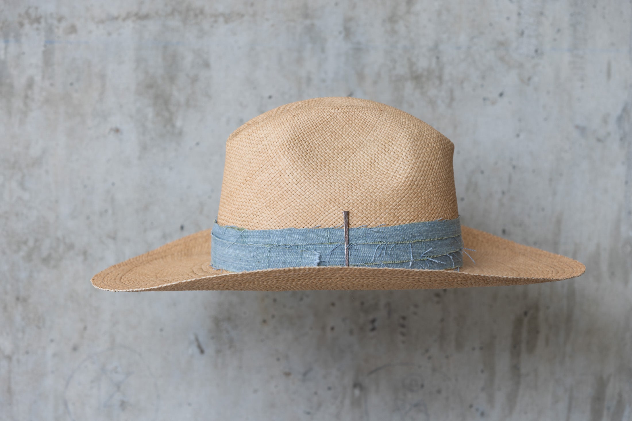Beige straw cowboy hat with light blue band left side