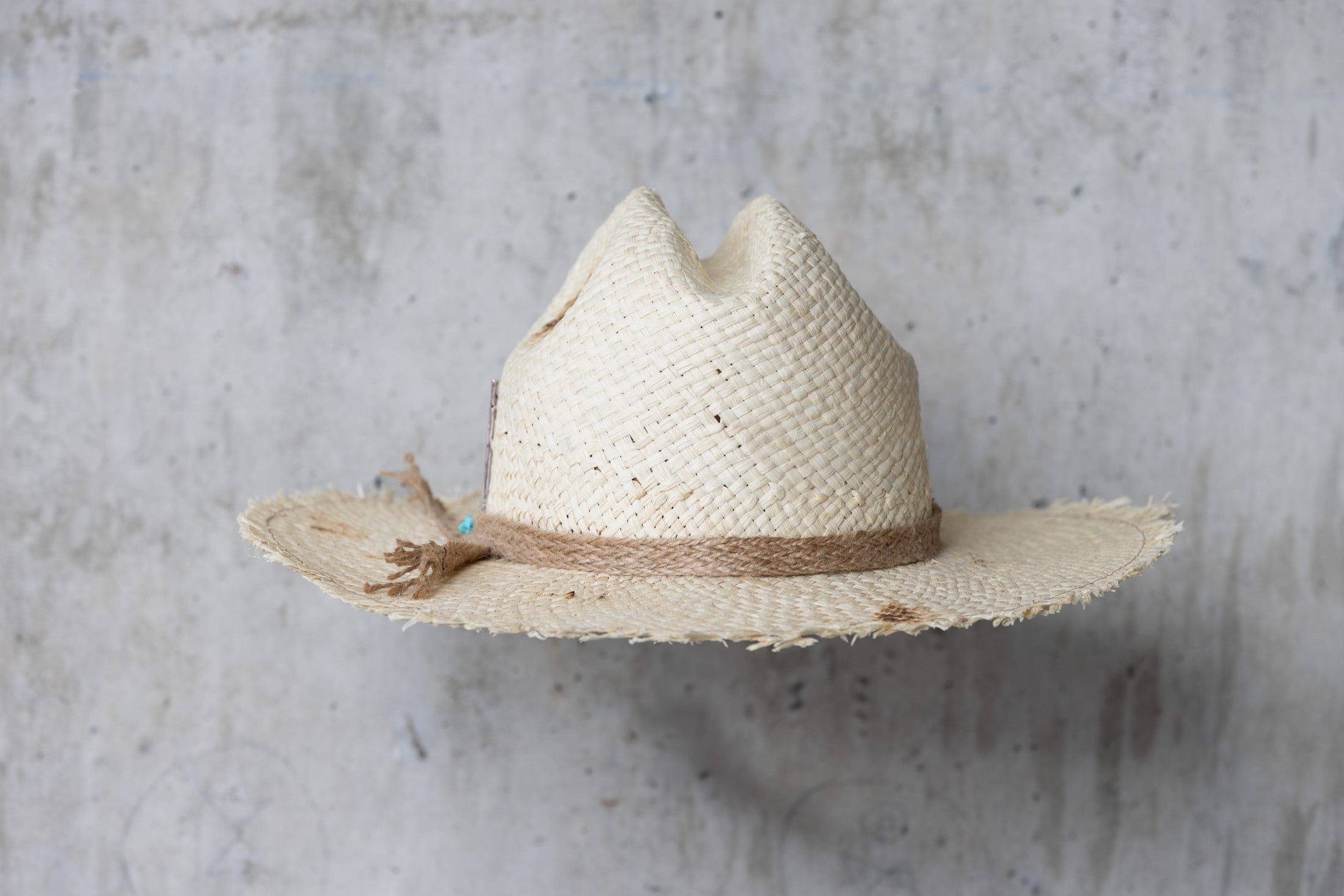 Beige colored straw cowboy hat with twine band and distressed look back side view