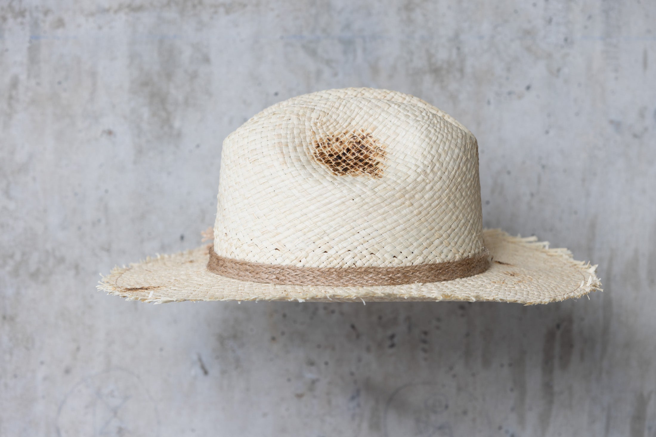 Beige colored straw cowboy hat with twine band and distressed look right side view