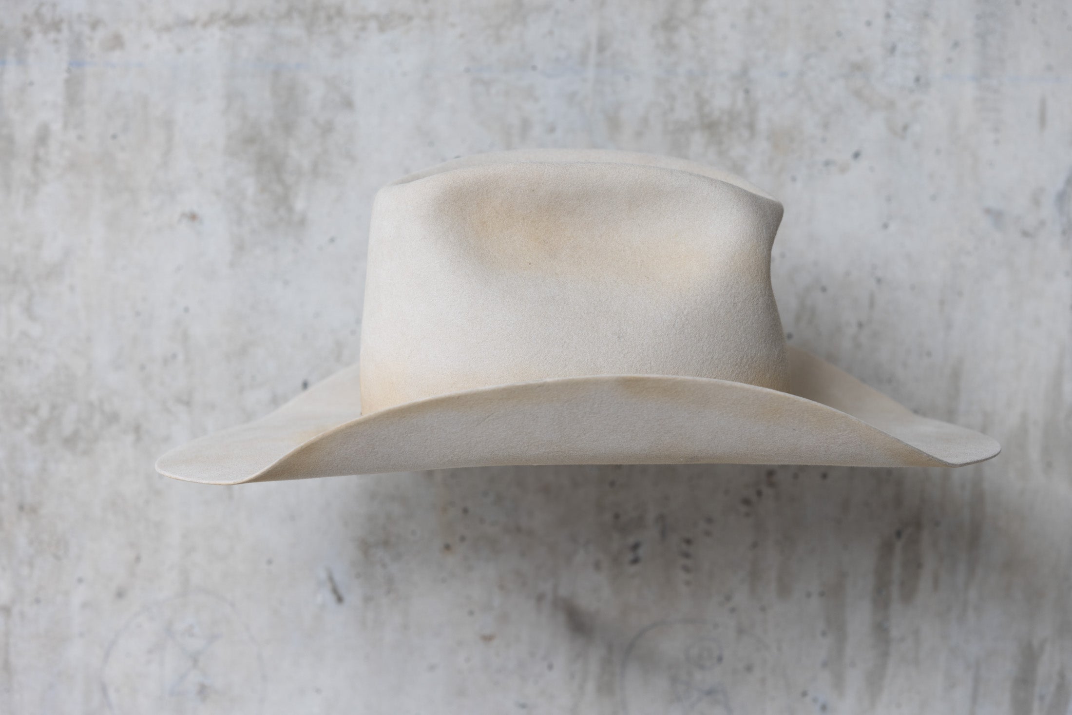 A beige, bone-colored cowboy hat with a mule kick and western flanged brim right side view