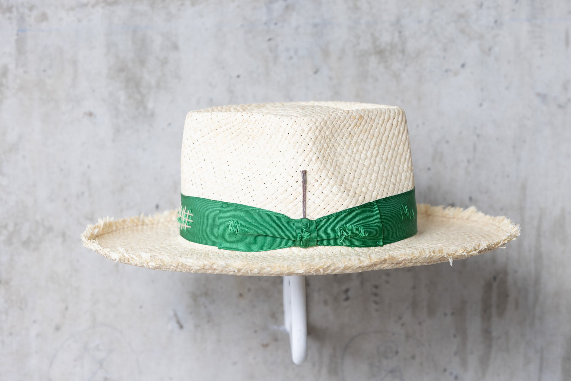 Beige straw hat with diamond shaped crown and green band left side