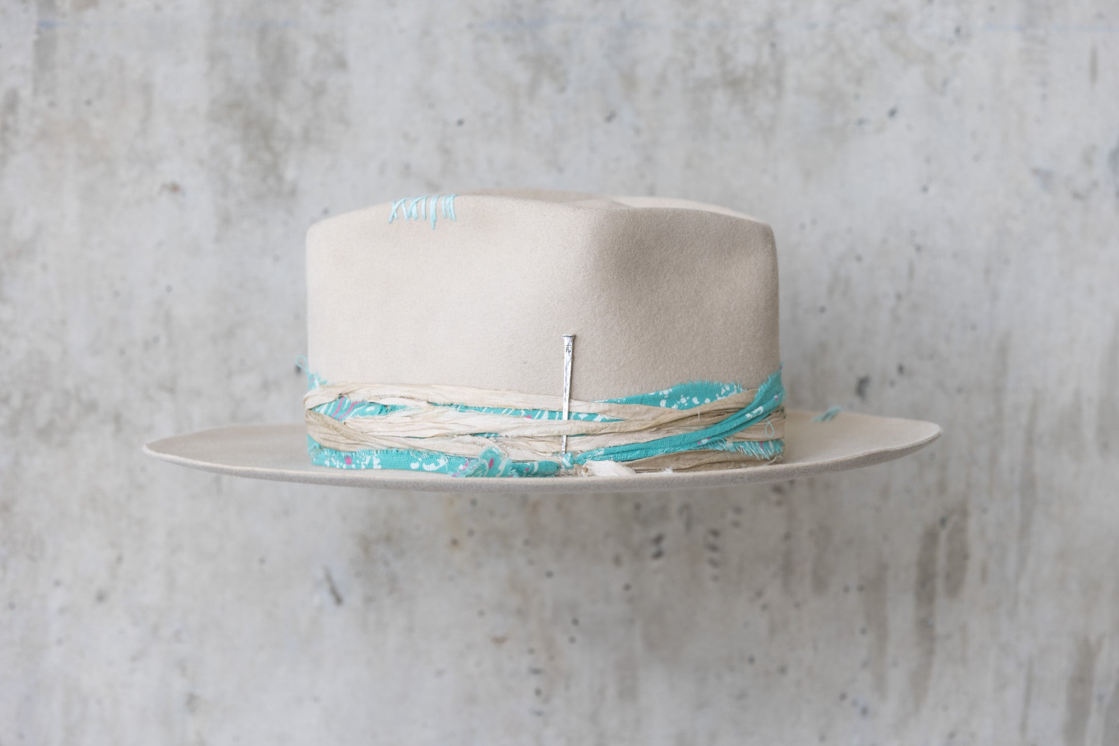 A sand colored fedora beaver felt hat with a teardrop crown and a vintage faded turquoise bandana for men and women left