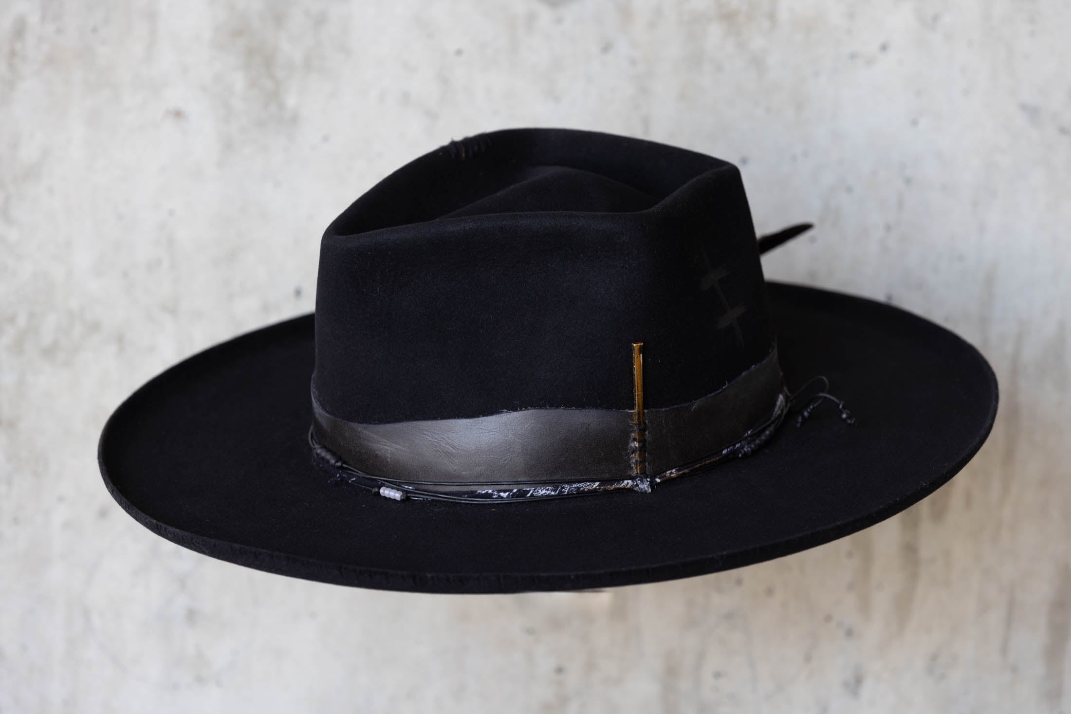 A black beaver felt hat with leather band and wide brim angle view