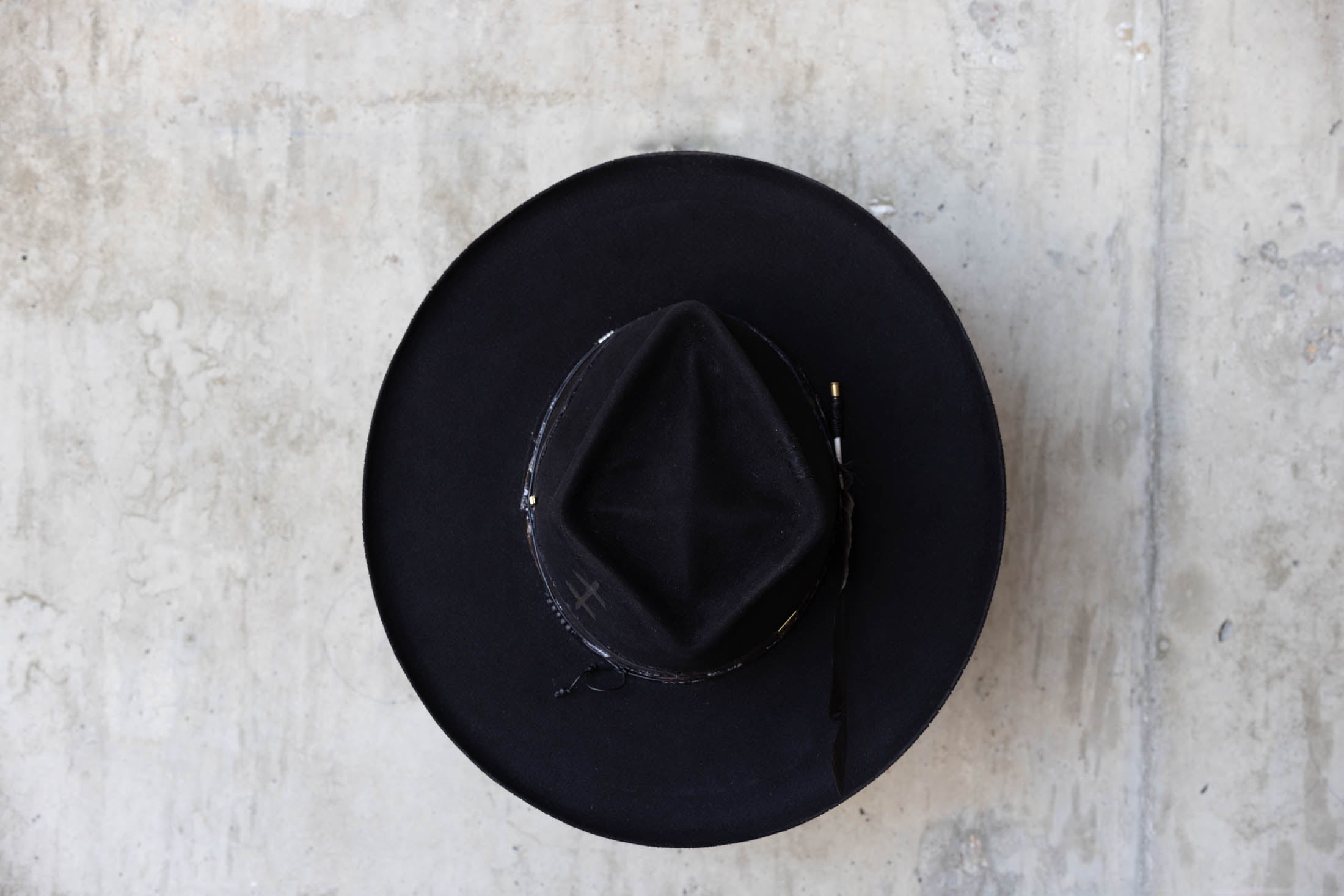 A black beaver felt hat with leather band and wide brim top view