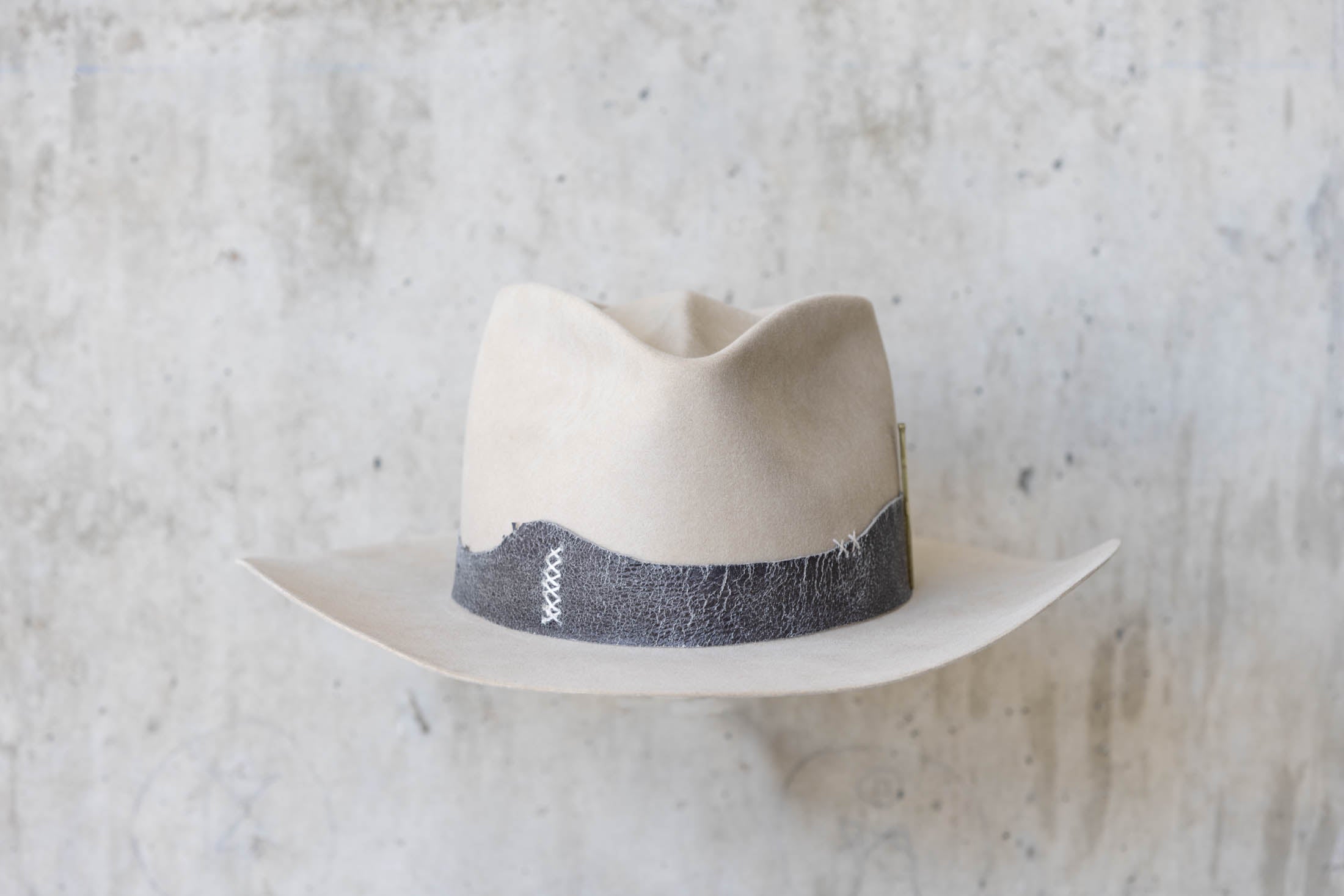 A beige western beaver felt cowboy hat with a leather band and brass nail detail for men and women front