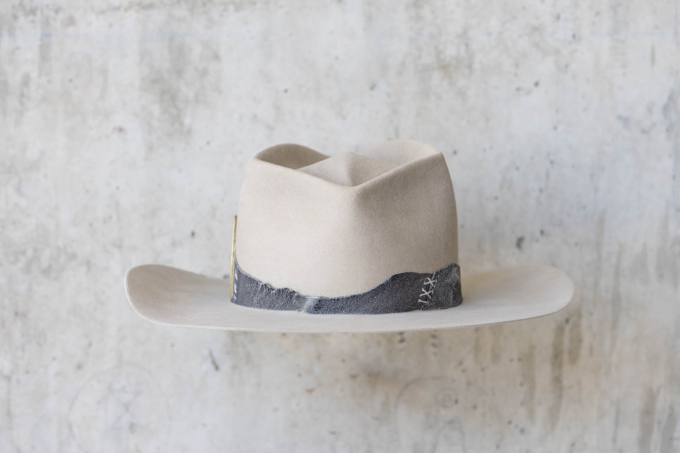 A beige western beaver felt cowboy hat with a leather band and brass nail detail for men and women back