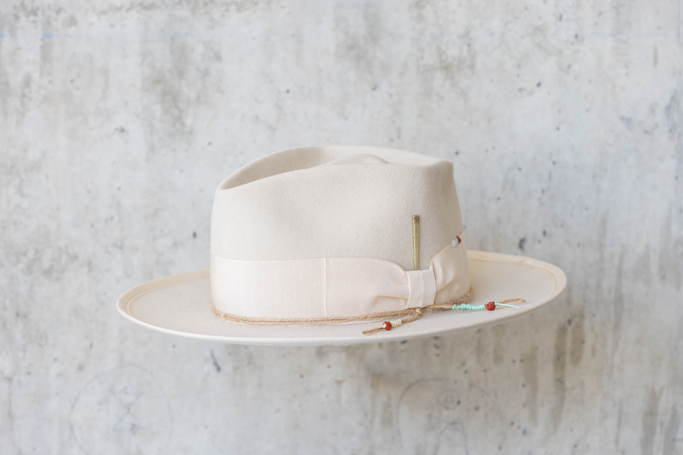 A beige beaver felt hat with beige ribbon angle view