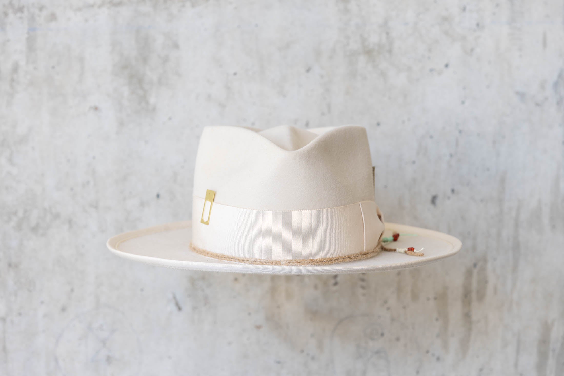 A beige beaver felt hat with beige ribbon front view