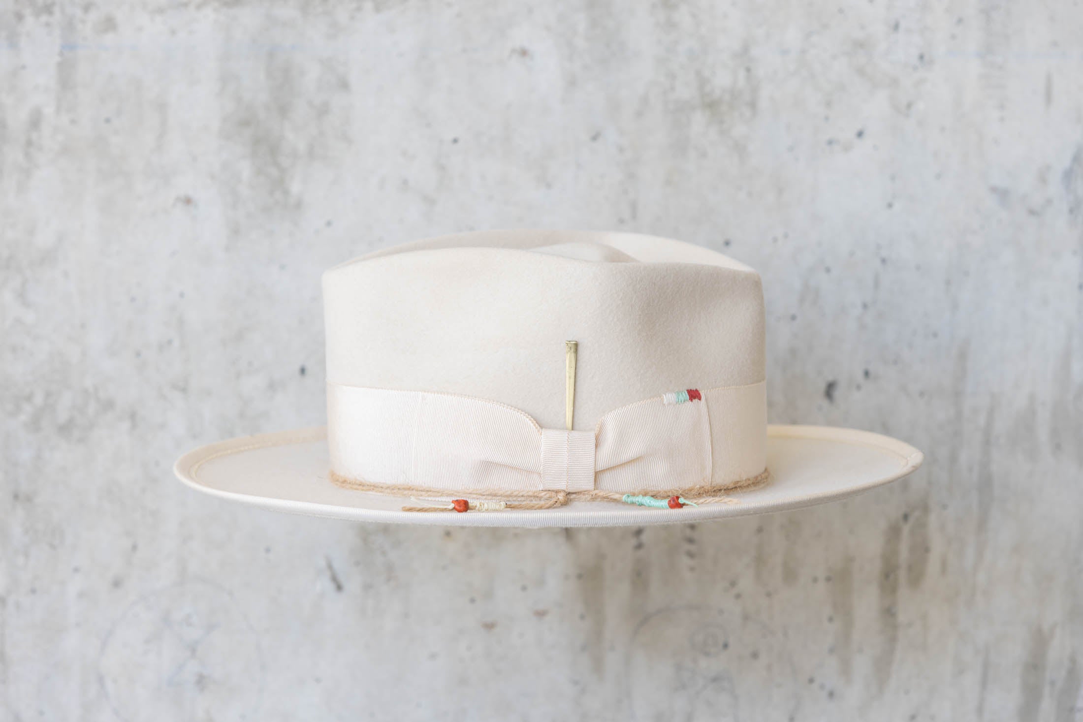 A beige beaver felt hat with beige ribbon left side