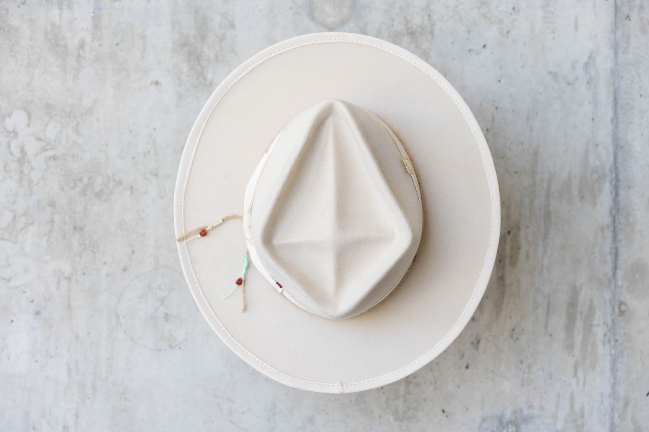 A beige beaver felt hat with diamond cross crown top view