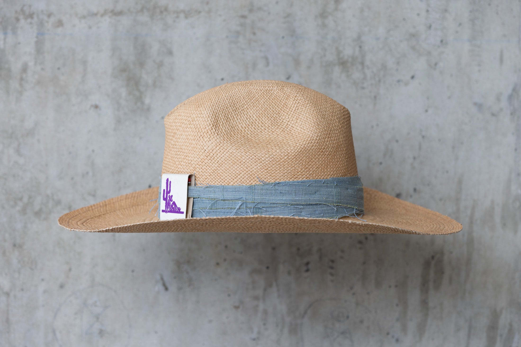 Beige straw cowboy hat with light blue band right side