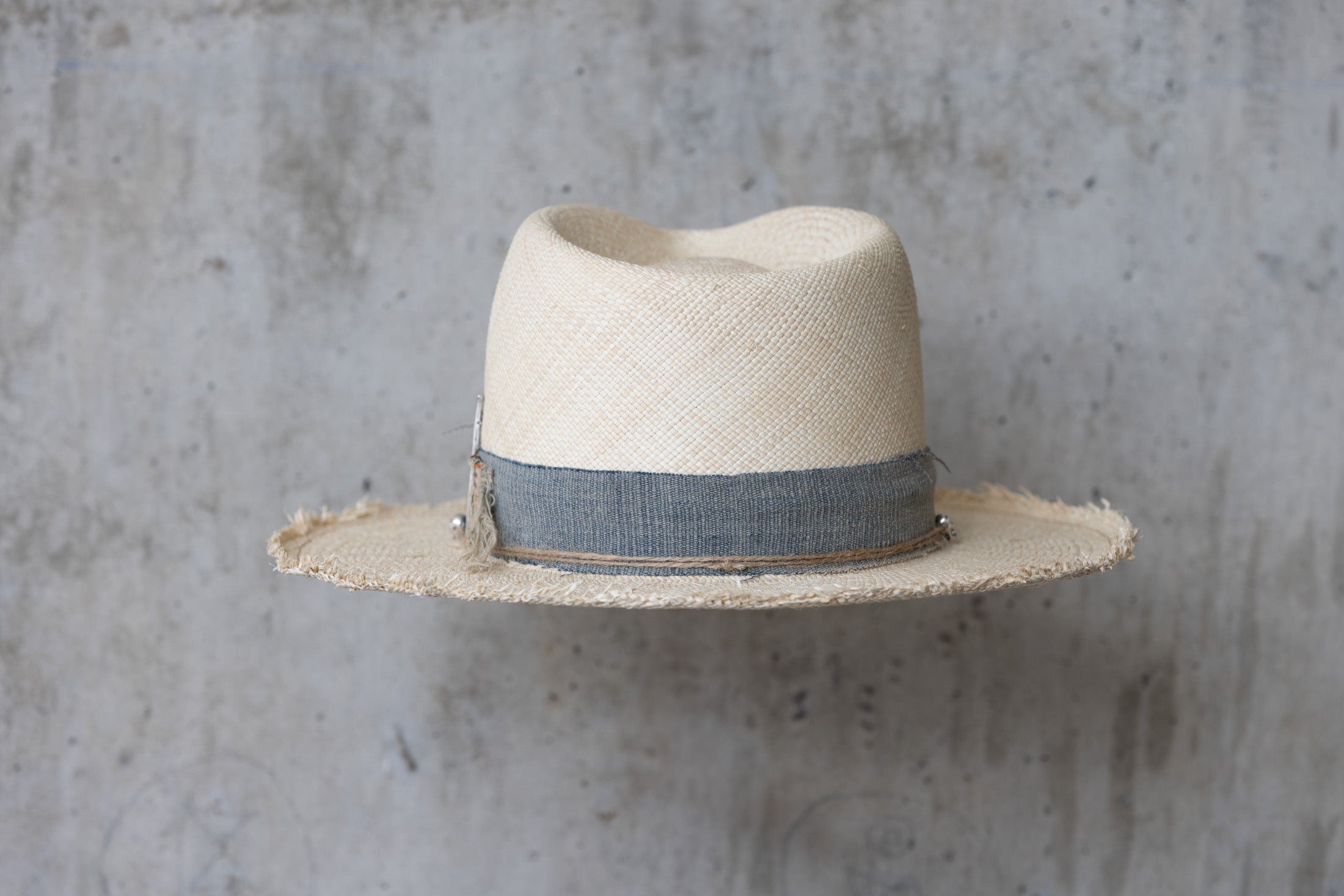 A beige Panama straw hat with a vintage blue band back