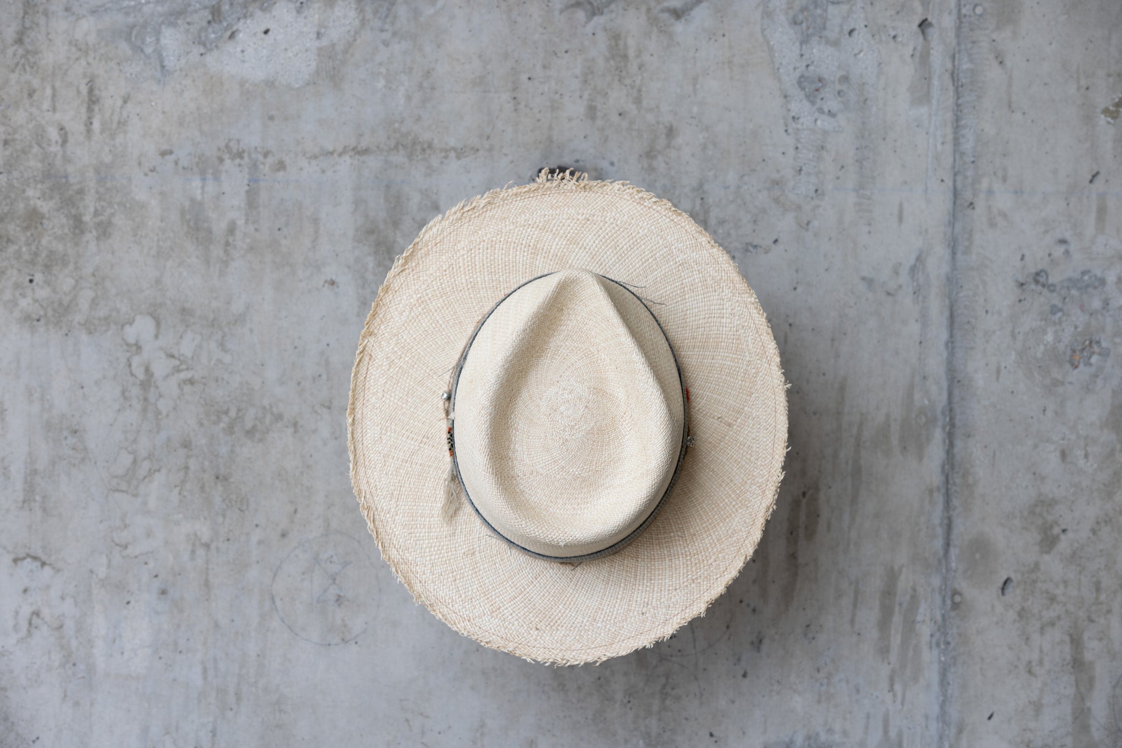 A beige Panama straw hat with a vintage blue band top