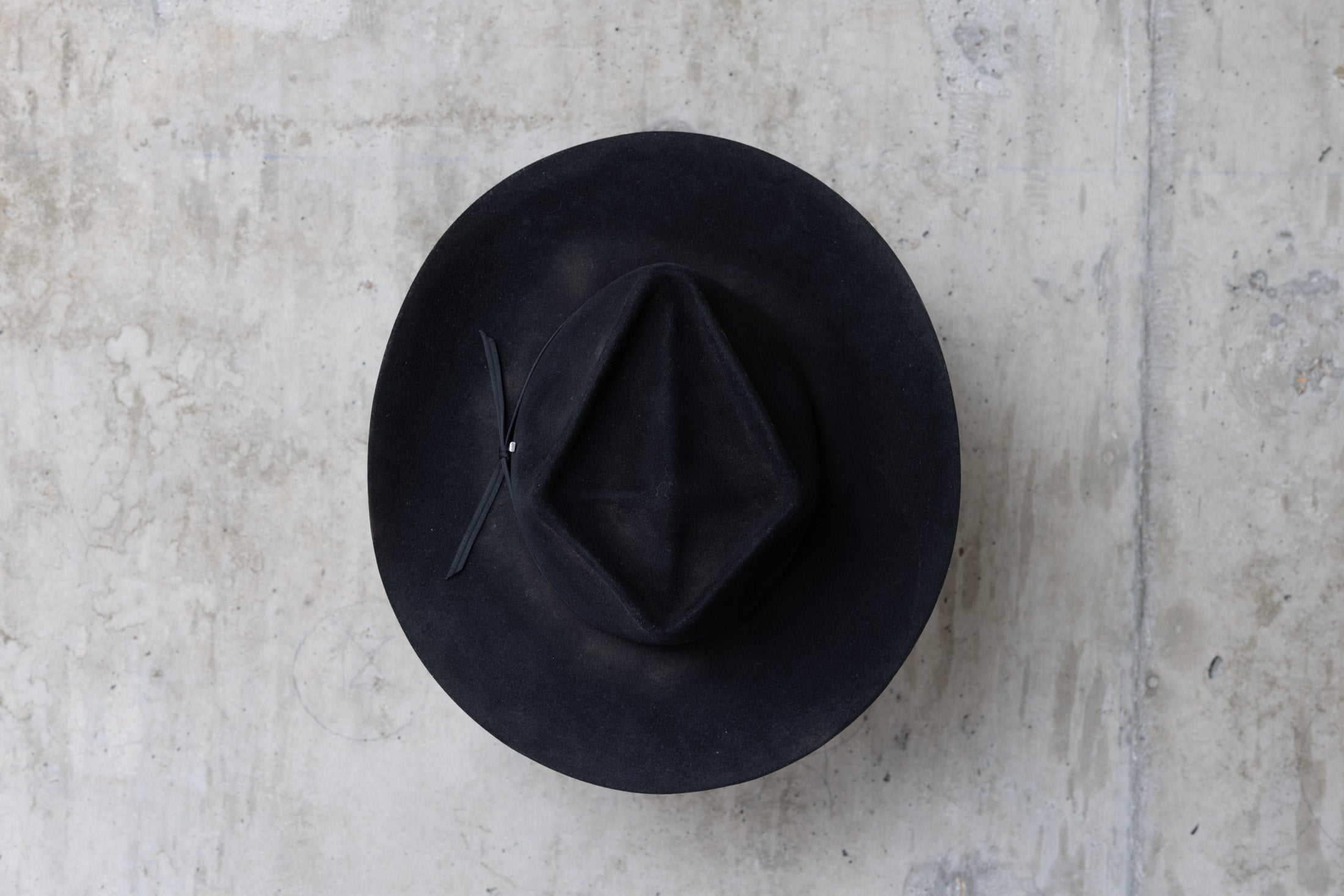 A black beaver felt western style hat with a diamond cross crown top view
