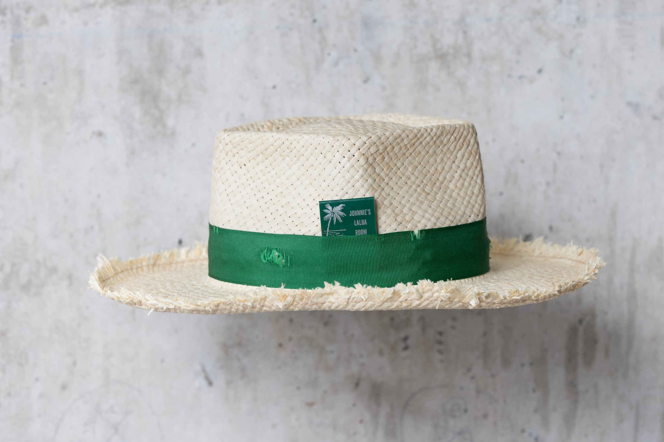 Beige straw hat with diamond shaped crown and green band right side