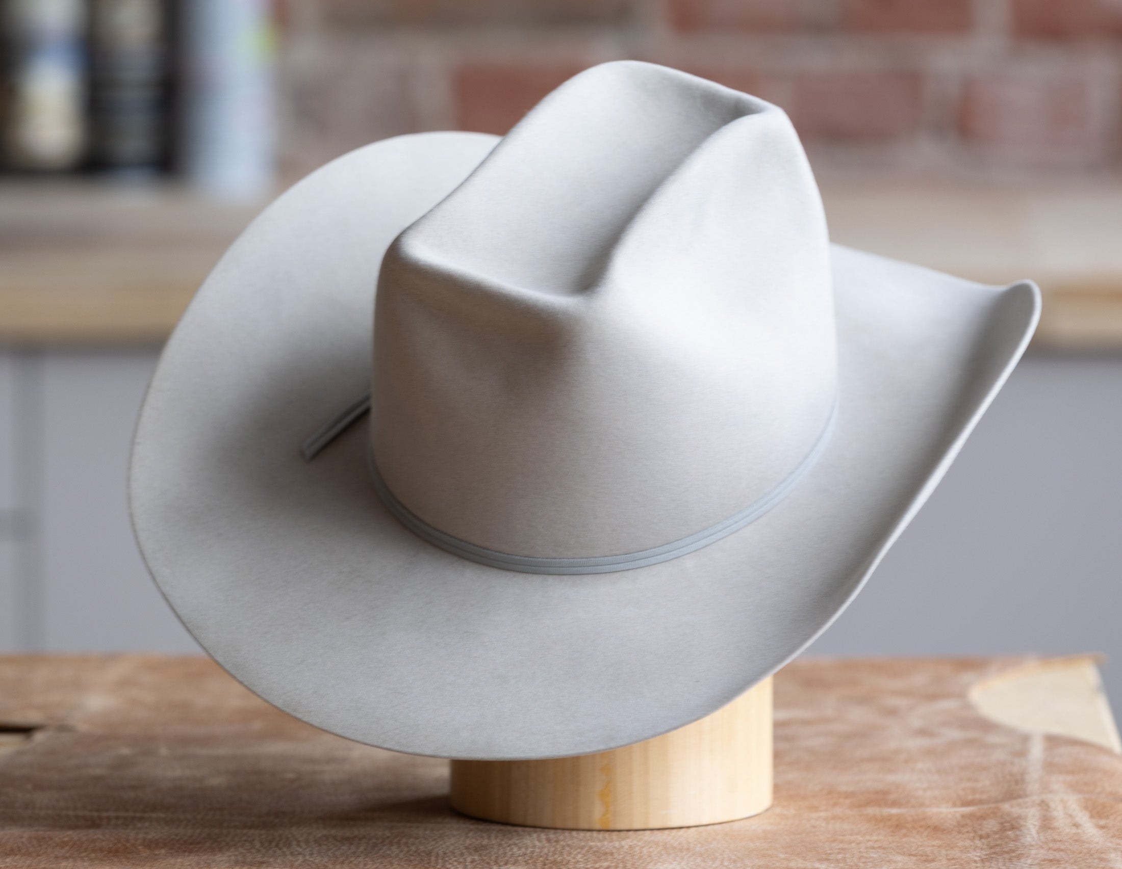 Grey Cowboy hat on a wood block back
