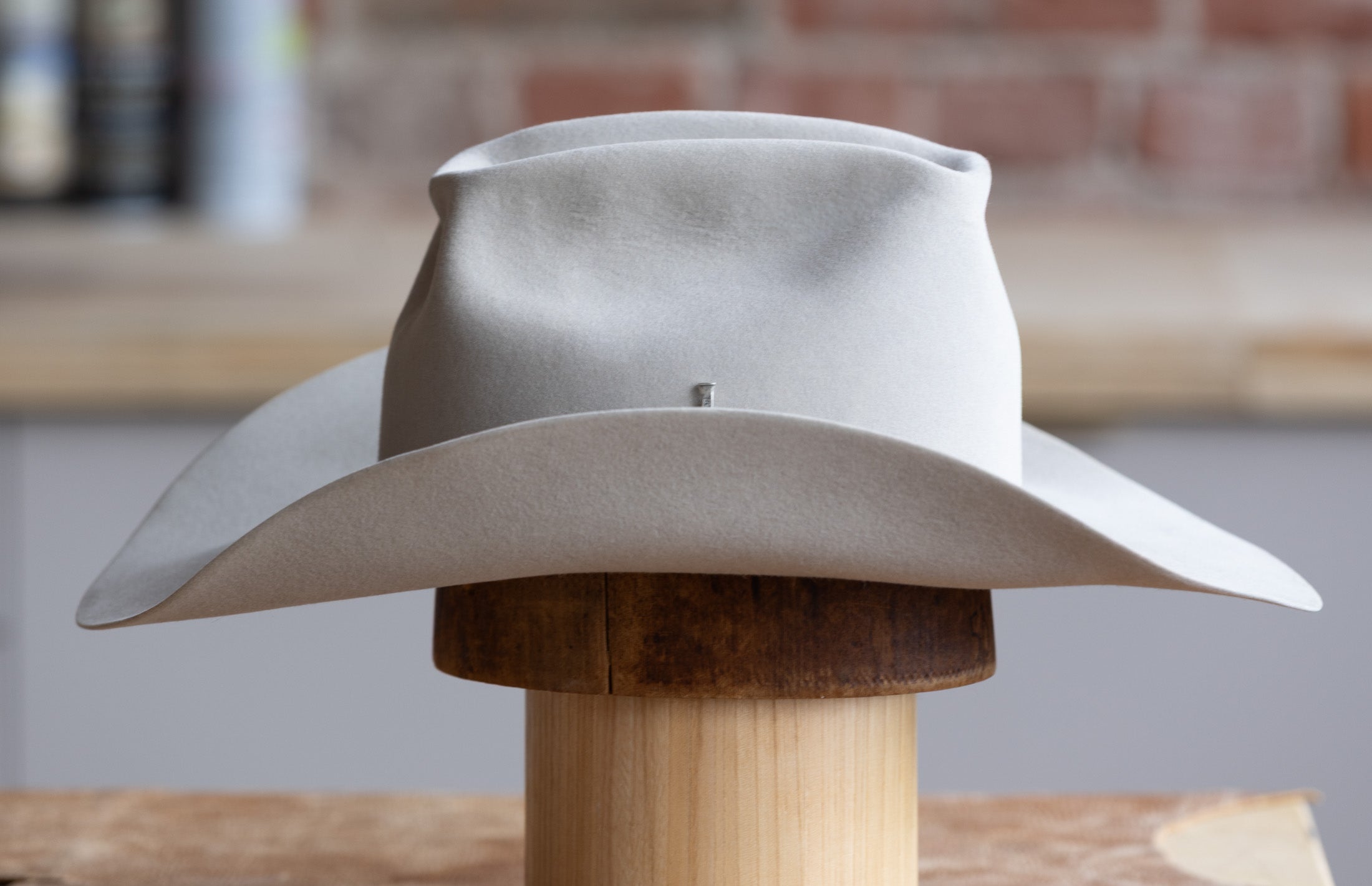 Grey Cowboy hat on a wood block side